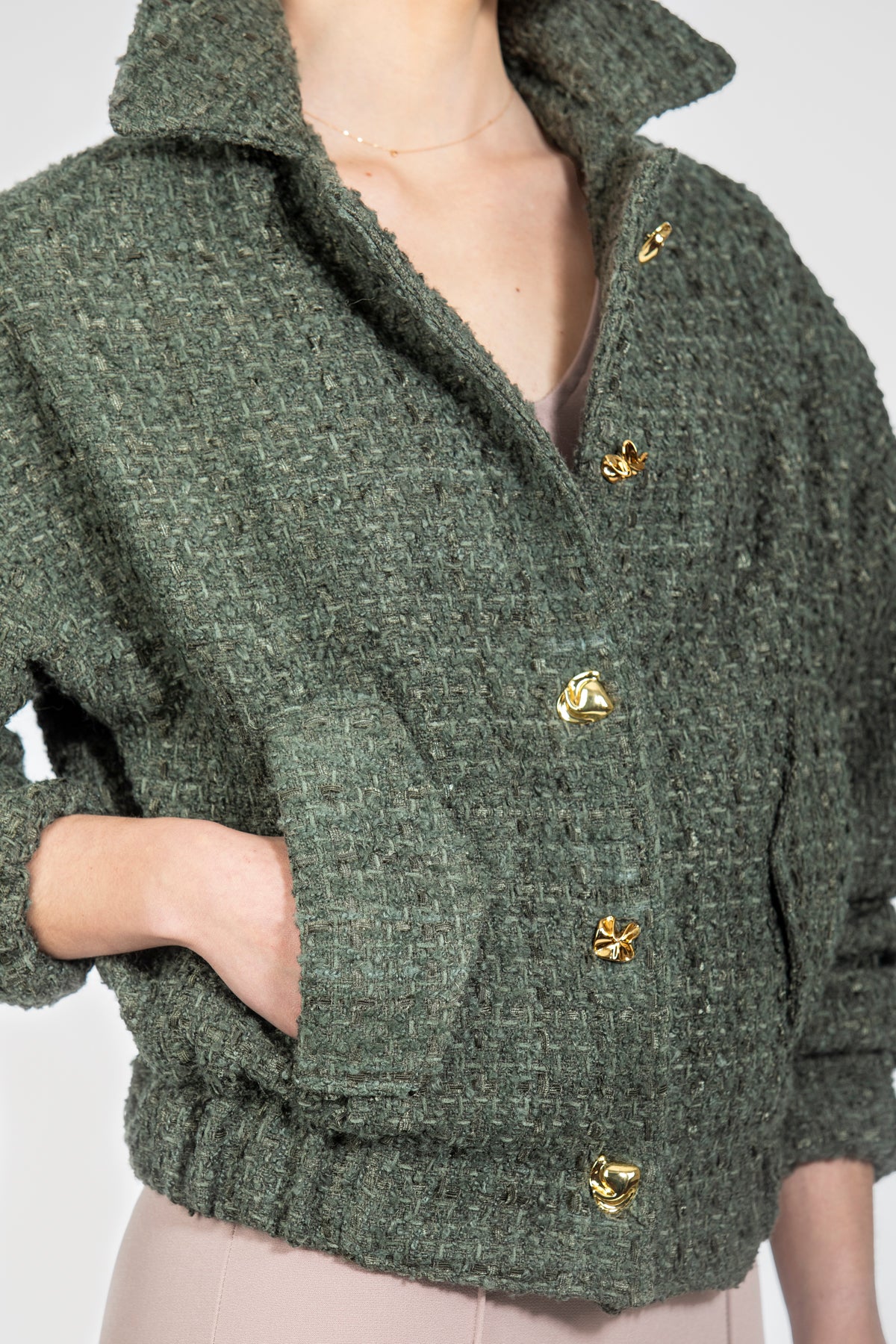 Tweed verde musgo con textura rústica y botones dorados, detalle - Kūpa